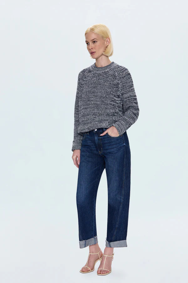 Person wearing a gray sweater and blue jeans on a light gray background